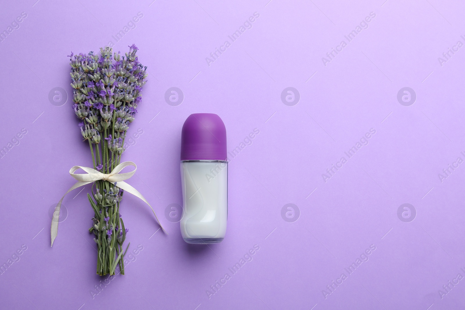 Photo of Female deodorant and lavender flowers on lilac background, flat lay. Space for text