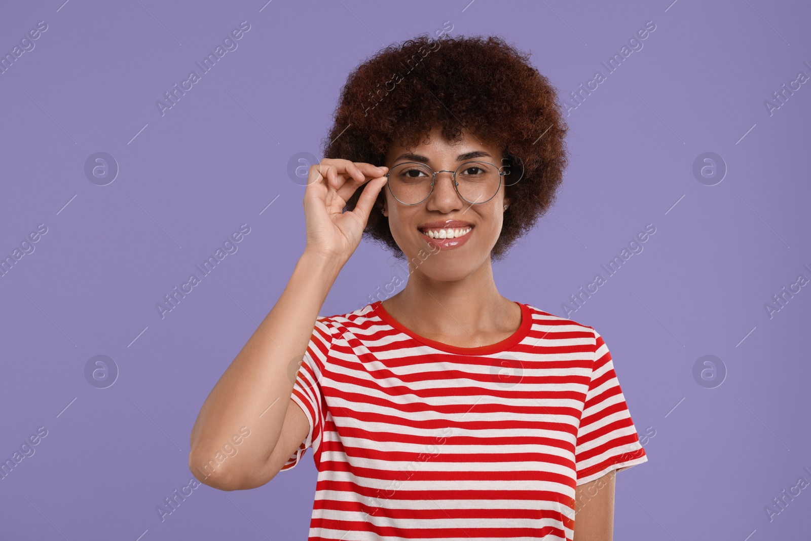 Photo of Portrait of happy young woman in eyeglasses on purple background