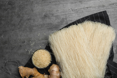 Flat lay composition with rice noodles on grey table, space for text