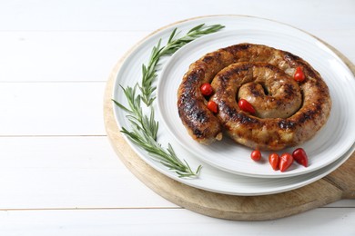 Photo of Tasty homemade sausages with peppers and rosemary on white wooden table, space for text