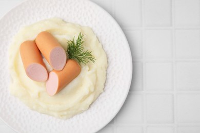 Photo of Delicious boiled sausages, mashed potato and dill on white tiled table, top view. Space for text