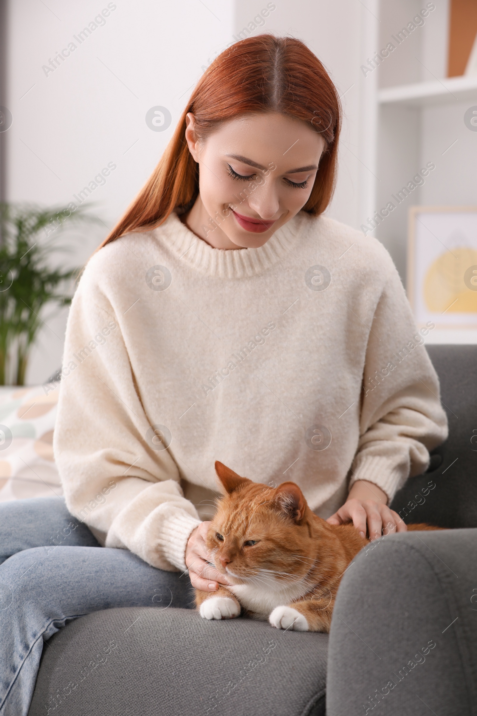 Photo of Woman with her cute cat on sofa at home