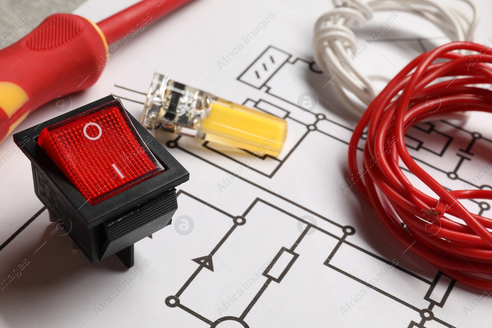 Photo of Wires and other electrician's equipment on wiring diagram, closeup