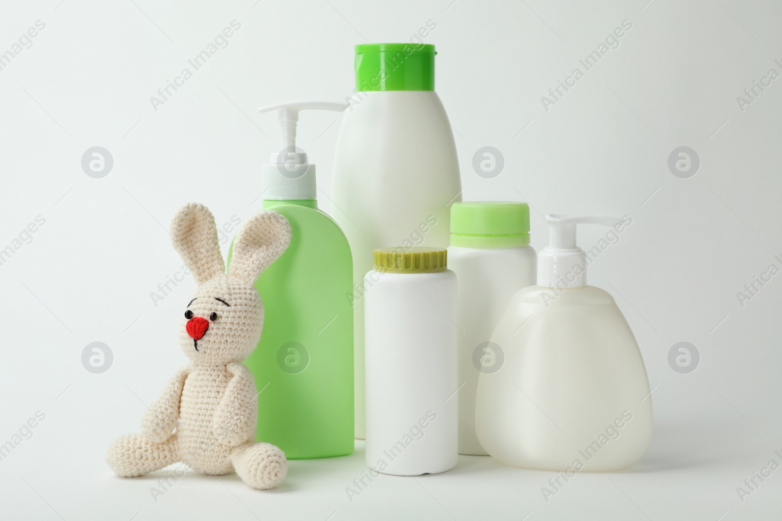 Photo of Baby cosmetic products and toy on white background