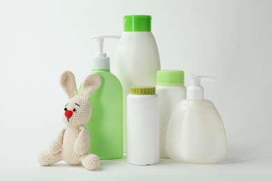 Baby cosmetic products and toy on white background