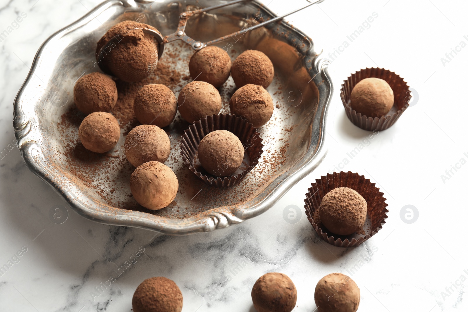 Photo of Plate and tasty chocolate truffles on marble background