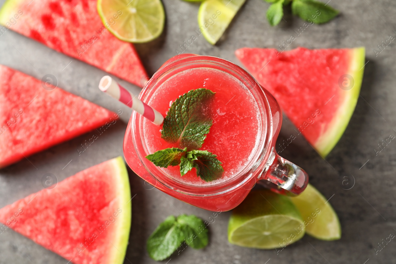 Photo of Summer watermelon drink in mason jar and sliced fruits on table, top view