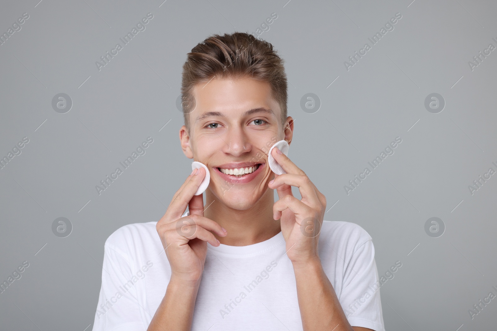 Photo of Handsome man with cotton pads on grey background