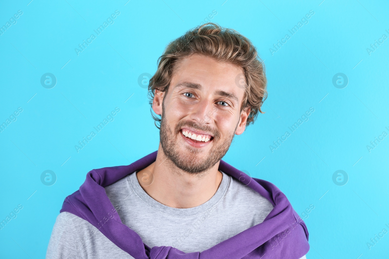 Photo of Handsome young man laughing on color background