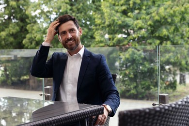 Handsome bearded man in cafe outdoors. Space for text