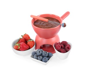 Photo of Fondue pot with melted chocolate, fresh berries and fork isolated on white
