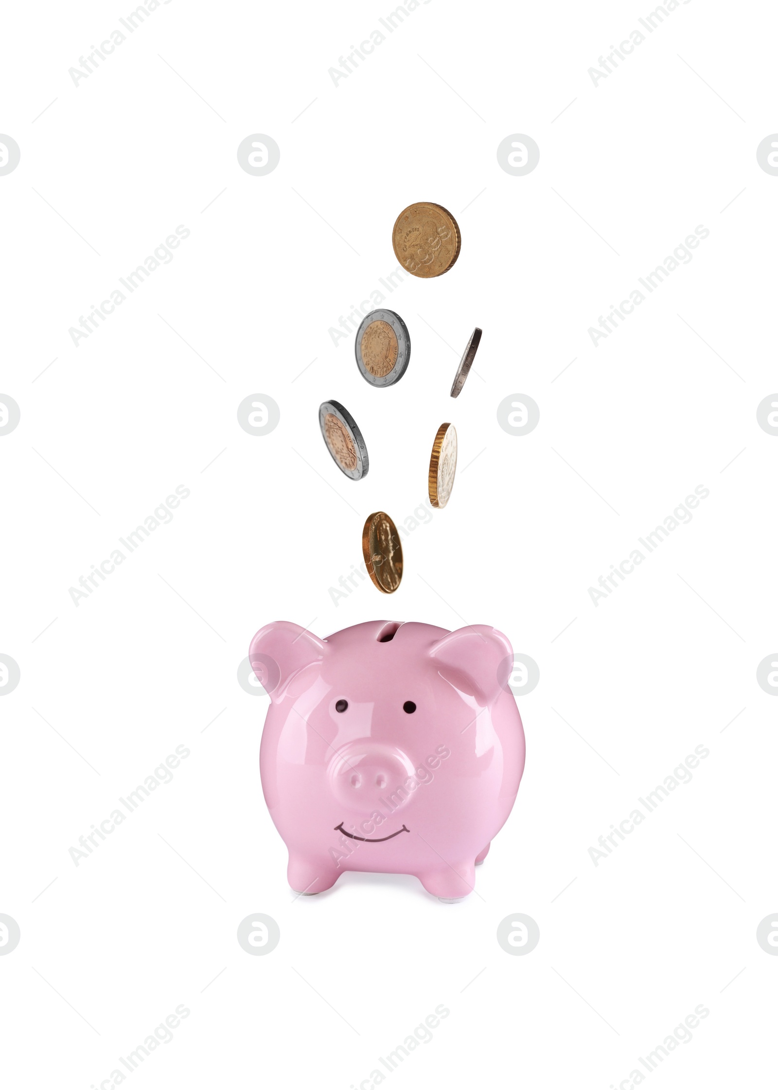 Image of Different coins falling into cute piggy bank on white background