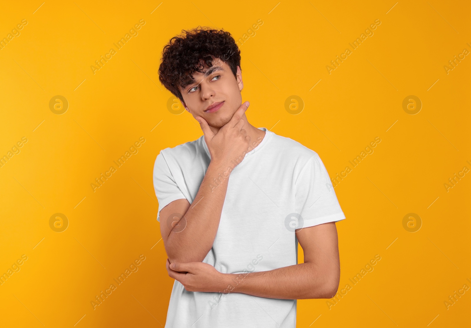 Photo of Portrait of handsome young man on orange background