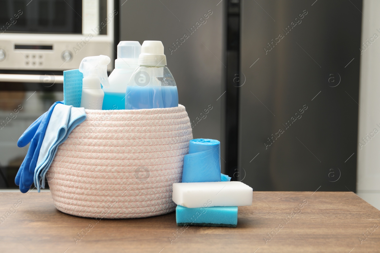 Photo of Different cleaning supplies in basket on table