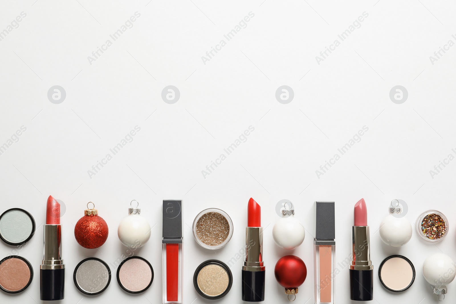 Photo of Flat lay composition with makeup products and Christmas decor on white background. Space for text