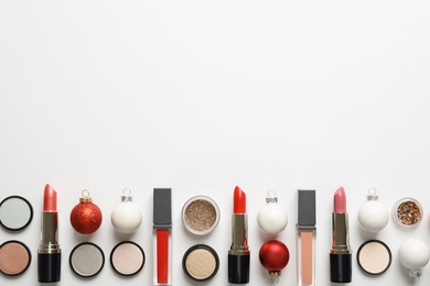 Photo of Flat lay composition with makeup products and Christmas decor on white background. Space for text