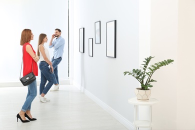 People viewing exposition in modern art gallery