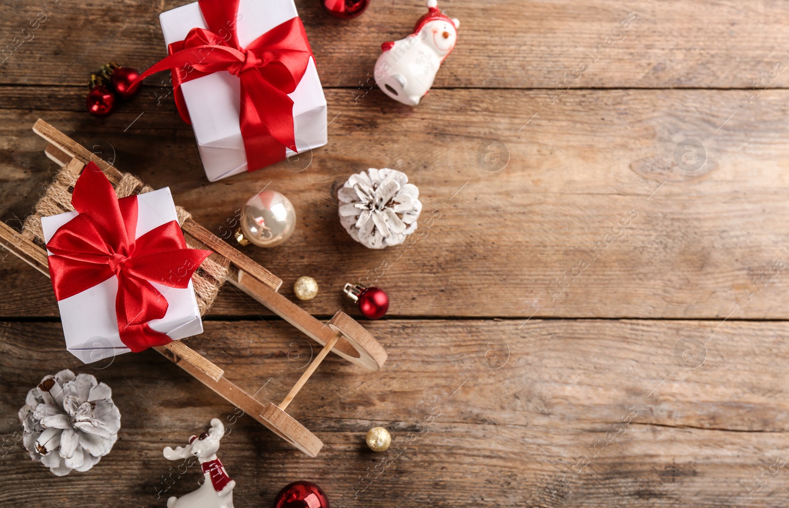 Photo of Beautiful Christmas composition with miniature sleigh on wooden table, flat lay. Space for text