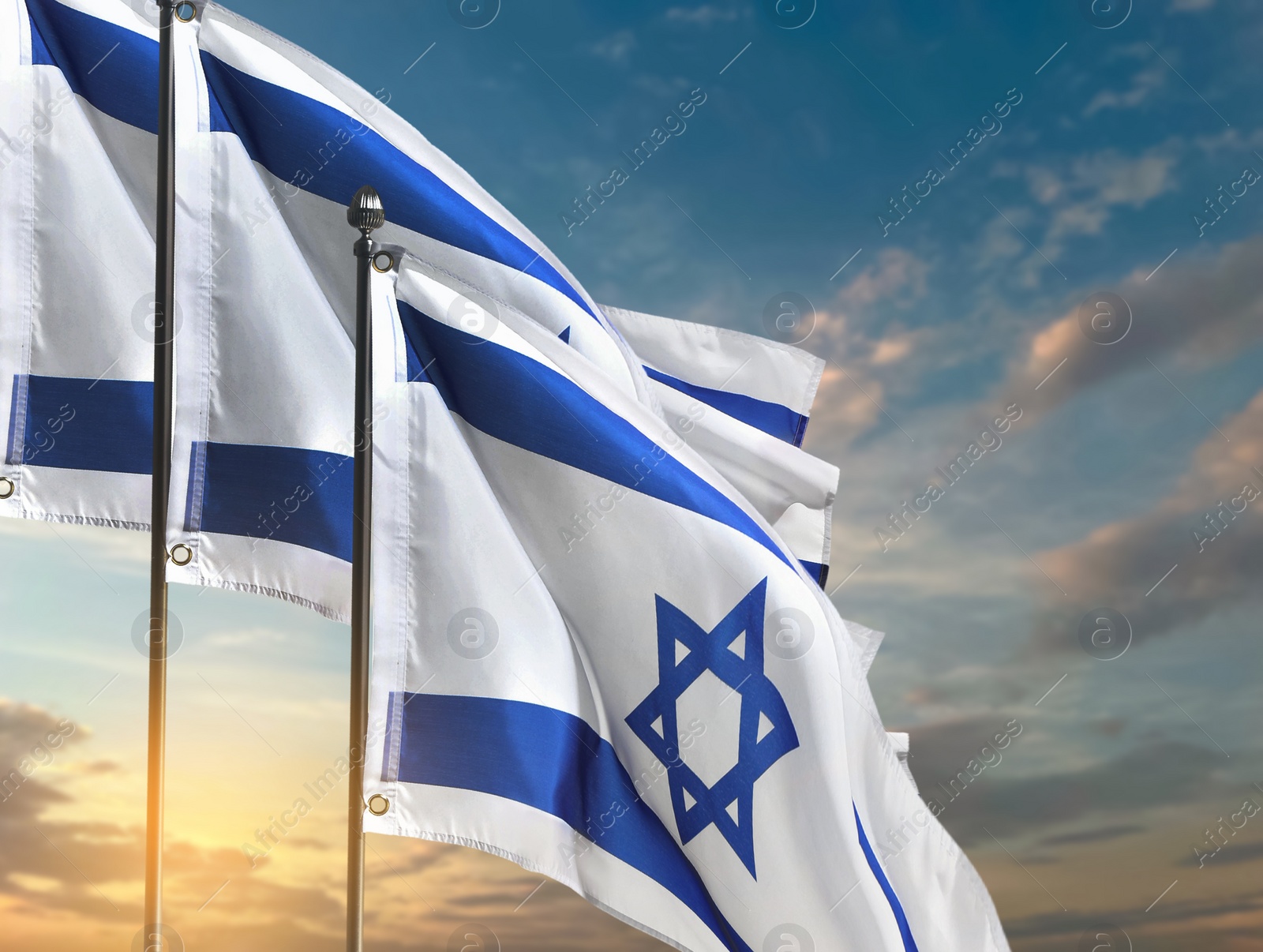 Image of National flags of Israel against blue sky with clouds