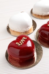 Photo of St. Valentine's Day. Delicious heart shaped cakes on white wooden table, closeup