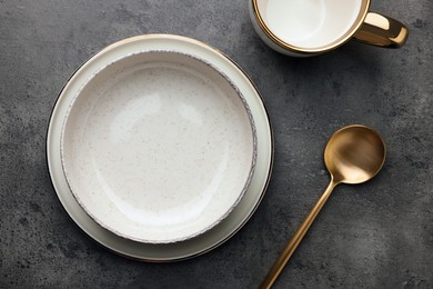 Photo of Stylish empty dishware and spoon on grey table, flat lay