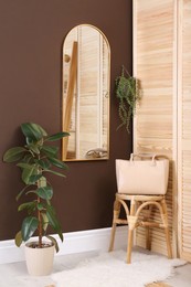 Stylish dressing room interior with mirror on brown wall