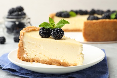 Photo of Piece of delicious cheesecake with blackberries on table, closeup