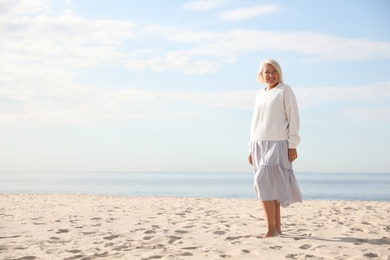 Beautiful mature woman on sea beach in summer