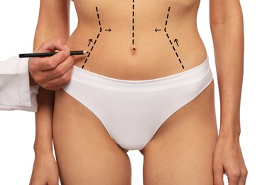 Image of Woman preparing for cosmetic surgery, white background. Doctor drawing markings on her abdomen, closeup