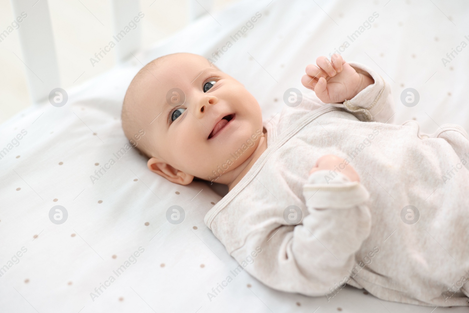 Photo of Cute little baby lying in crib at home