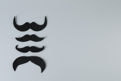 Photo of Fake paper mustaches on grey background, flat lay. Space for text