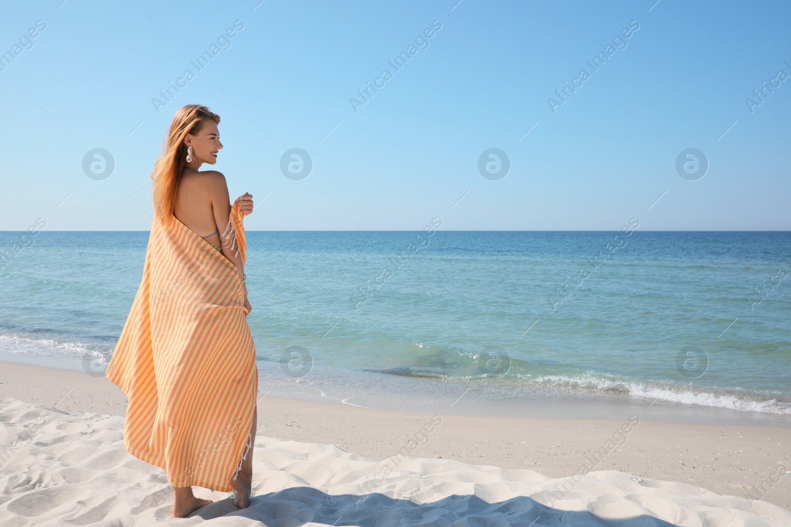 Photo of Woman with beach towel near sea on sunny day