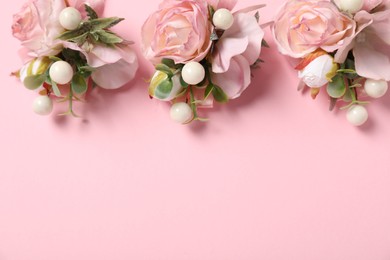 Photo of Stylish boutonnieres on pink background, flat lay. Space for text