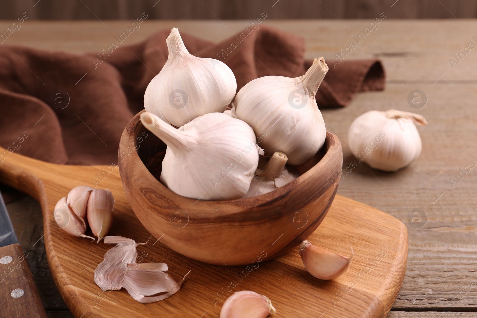 Photo of Fresh garlic and knife on wooden table, closeup