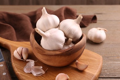 Photo of Fresh garlic and knife on wooden table, closeup