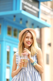 Photo of Young woman with cup of tasty lemonade outdoors