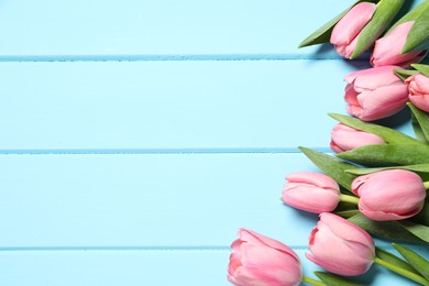 Happy Mother's Day. Beautiful pink tulips on light blue wooden table, flat lay. Space for text