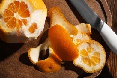 Juicy orange and peels on wooden table, top view