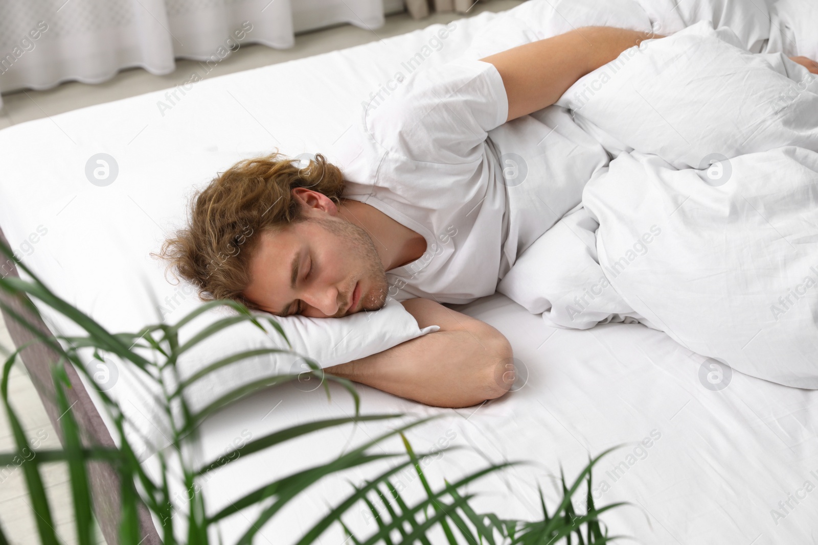 Photo of Handsome young man sleeping on pillow at home. Bedtime