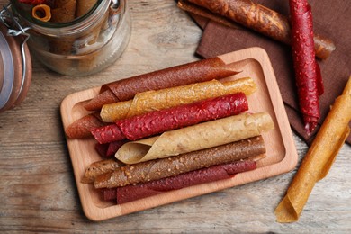 Photo of Delicious fruit leather rolls on wooden table, flat lay