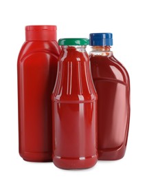 Different bottles of ketchup on white background