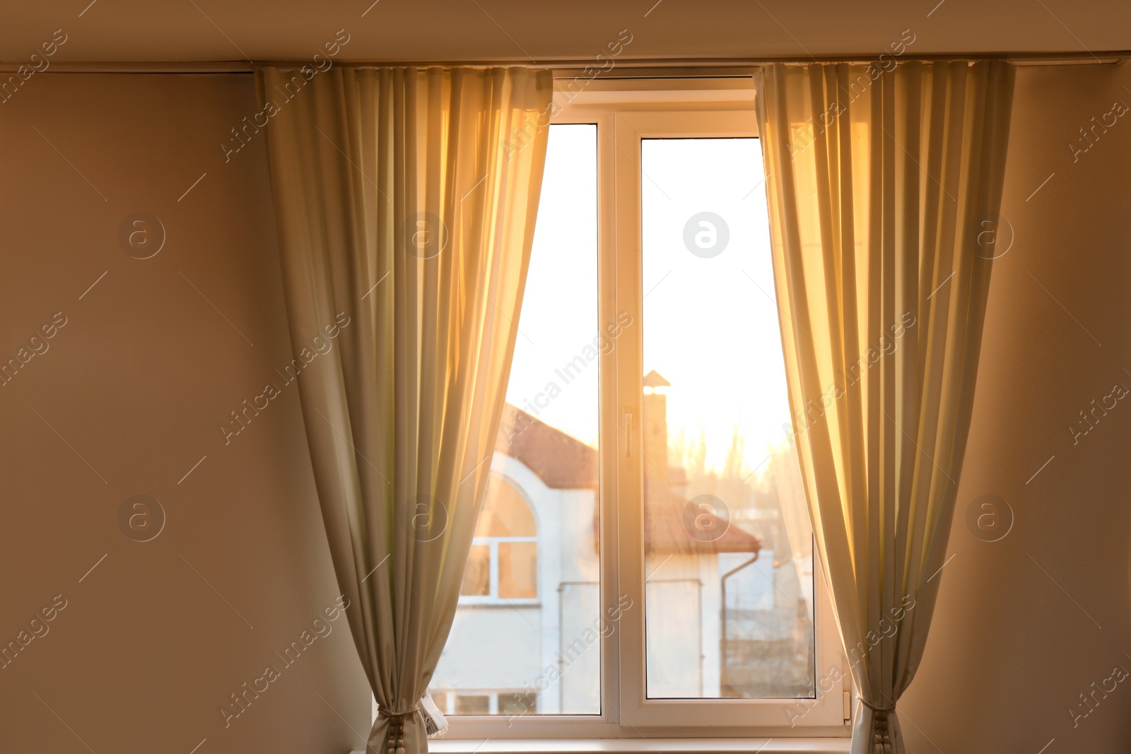 Photo of Window with beautiful beige curtains. Room decoration