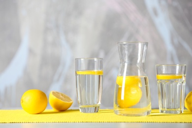 Photo of Glassware with water and slices of lemon on table