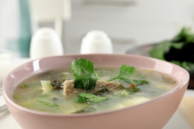 Delicious sorrel soup with meat and parsley in pink bowl, closeup