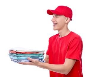 Photo of Dry-cleaning delivery. Happy courier holding folded clothes on white background