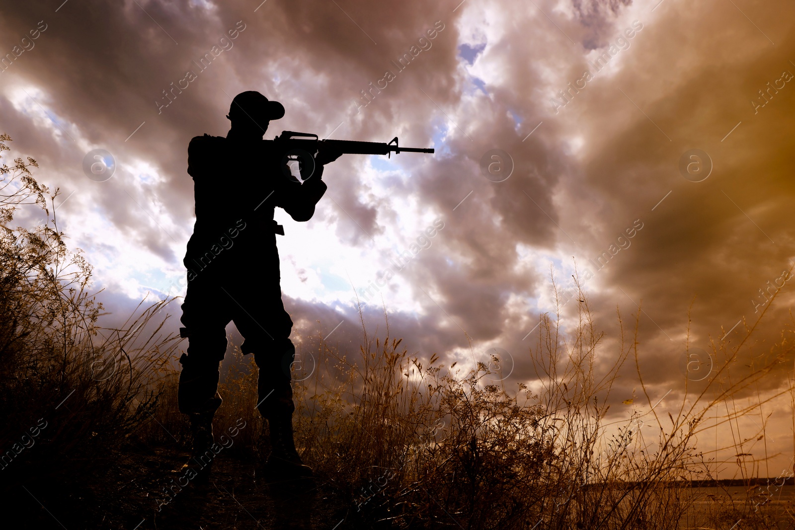 Photo of Soldier with machine gun patrolling outdoors. Military service