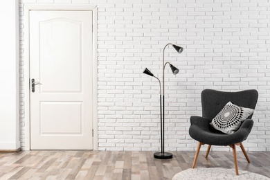 Photo of Light room interior with white door in brick wall