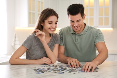 Photo of Happy couple playing with puzzles at home