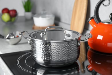 Photo of Pot with lid on cooktop in kitchen. Cooking utensil
