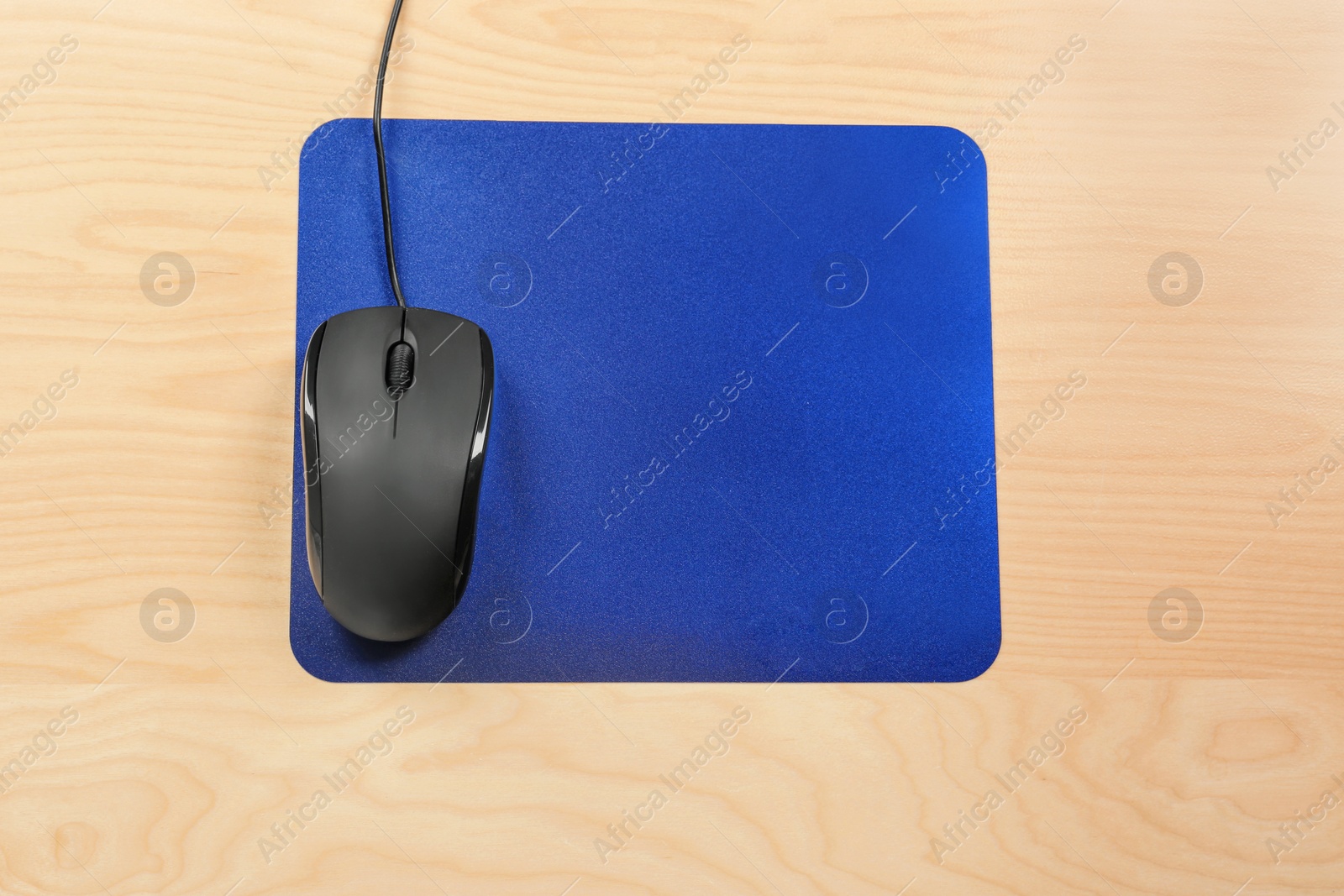 Photo of Blank mat and modern computer mouse on wooden background